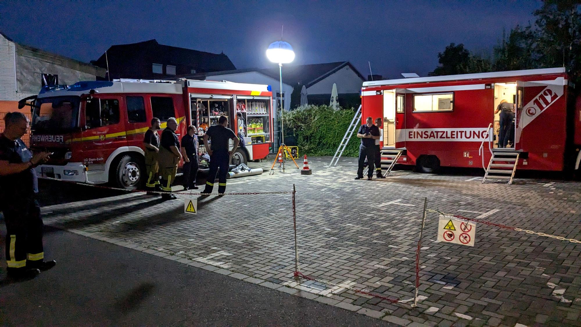 Zwei Einsatzfahrzeuge der Feuerwehr stehen in der Dunkelheit auf einem Parkplatz in Mechernich. Ein Powermoon beleuchtet die Szenerie.