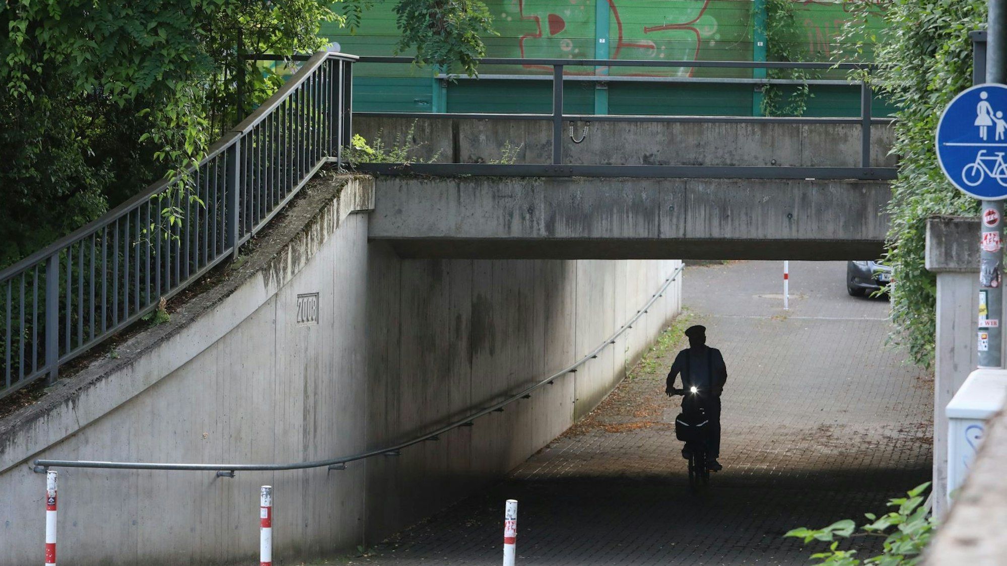 Ein Radfahrer führt durch eine Unterführung.