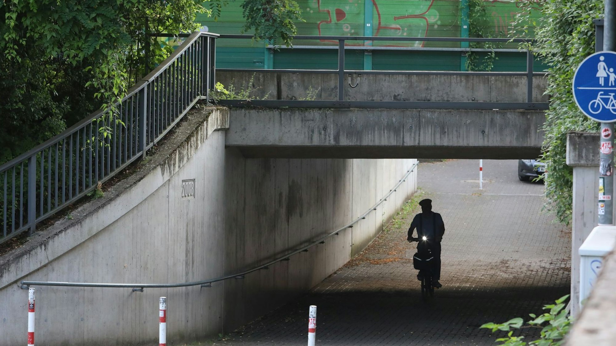 Ein Radfahrer führt durch eine Unterführung.