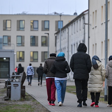 Migranten gehen über das Gelände der Zentralen Erstaufnahmeeinrichtung für Asylbewerber (ZABH) des Landes Brandenburg in Eisenhüttenstadt. (Symbolbild)