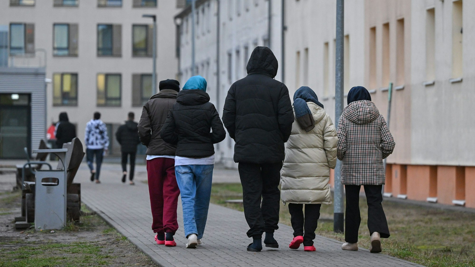 Migranten gehen über das Gelände der Zentralen Erstaufnahmeeinrichtung für Asylbewerber (ZABH) des Landes Brandenburg in Eisenhüttenstadt. (Symbolbild)