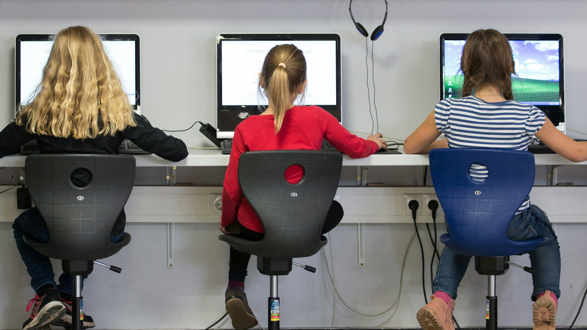 Schülerinnen arbeiten in einem Klassenraum an Computern.