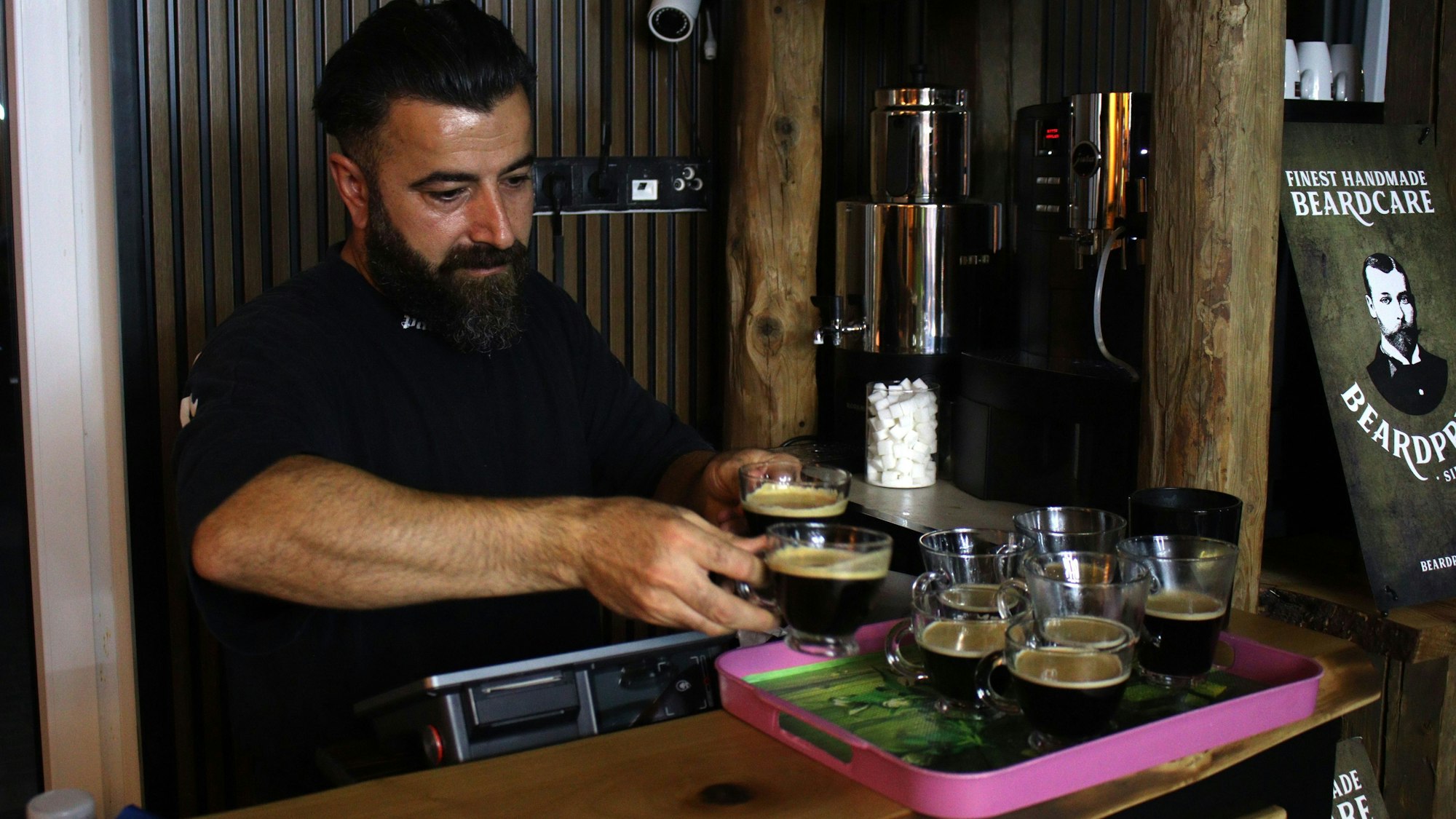 Idris Bozan stellt einige Kaffeetassen auf ein Tablett.