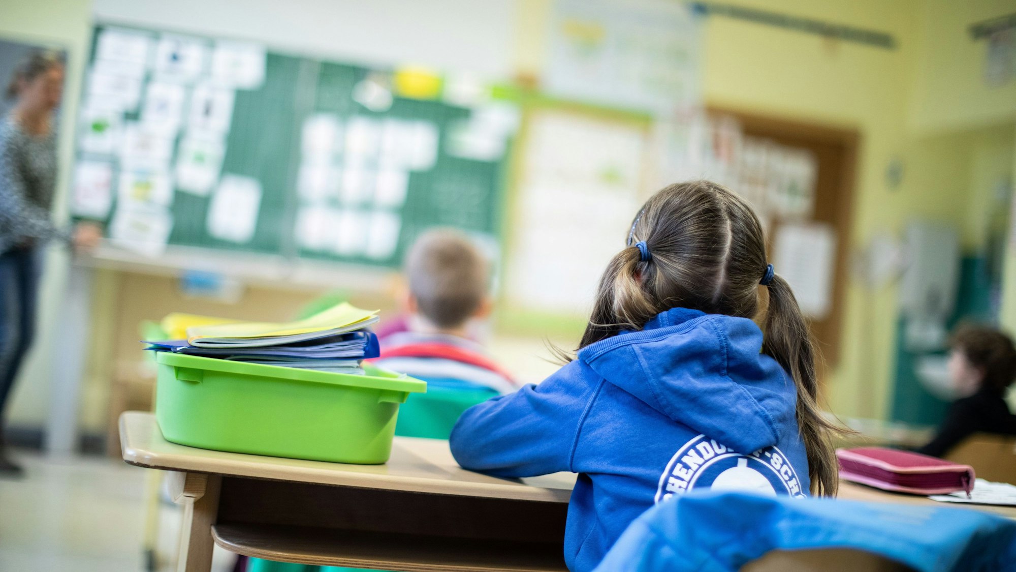 Schülerinnen und Schüler einer Grundschule sitzen mit Abstand in ihrem Klassenraum.