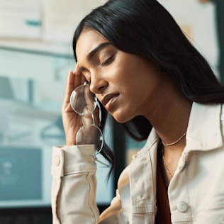 Eine Frau hält sich ihren Kopf