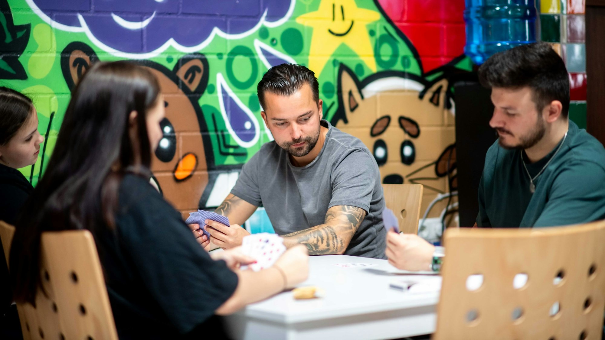 Erwachsene Spielen mit Kindern Karten an einem Tisch.