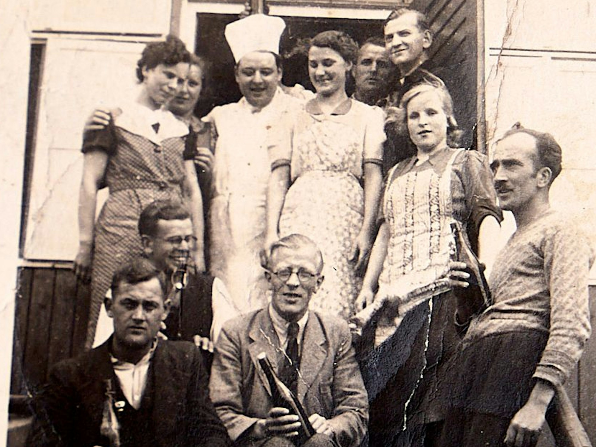 Menschen sitzen und stehen auf einer Treppe.