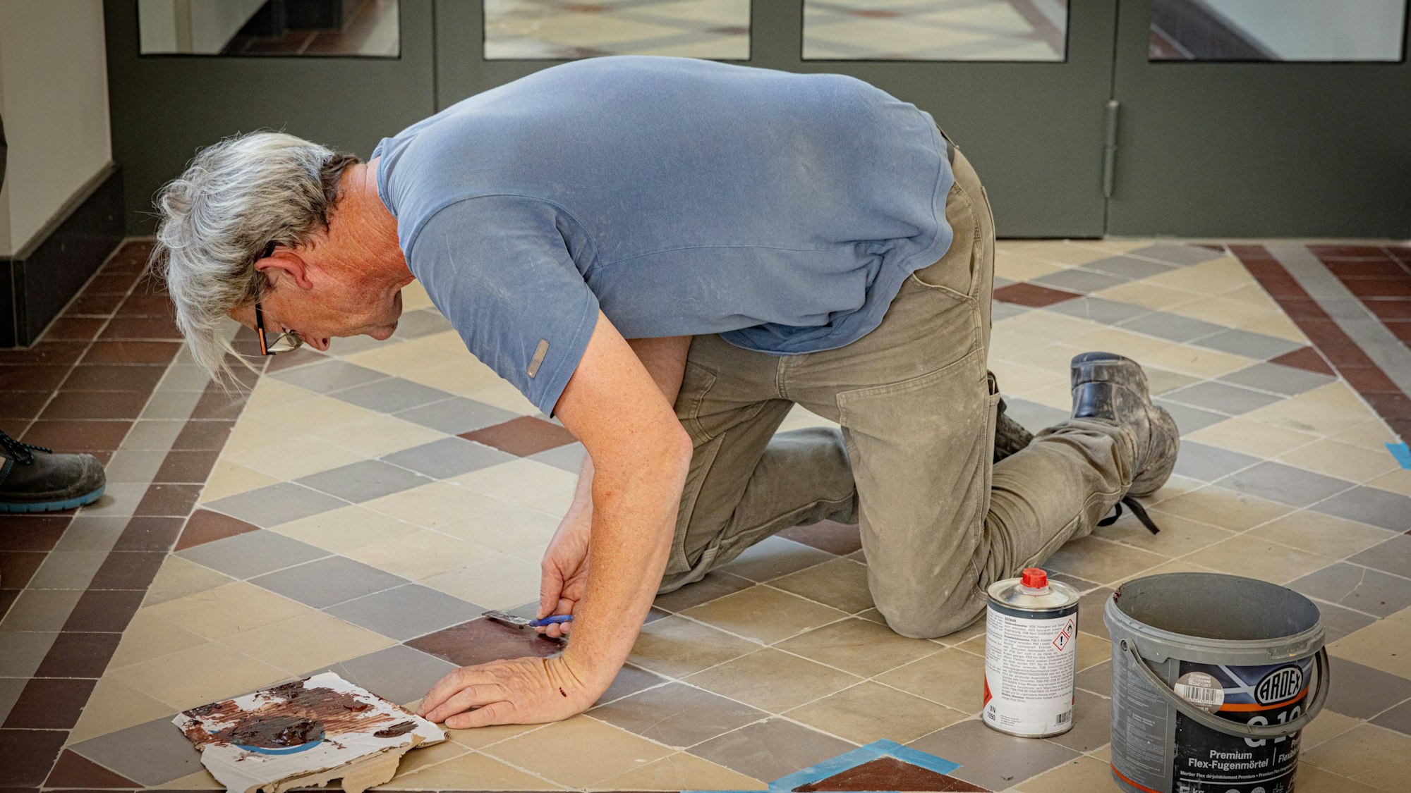 Ausbessern der historischen Bodenkacheln.