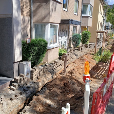 Baustelle für Glasfaserkabel vor einem Wohnhaus