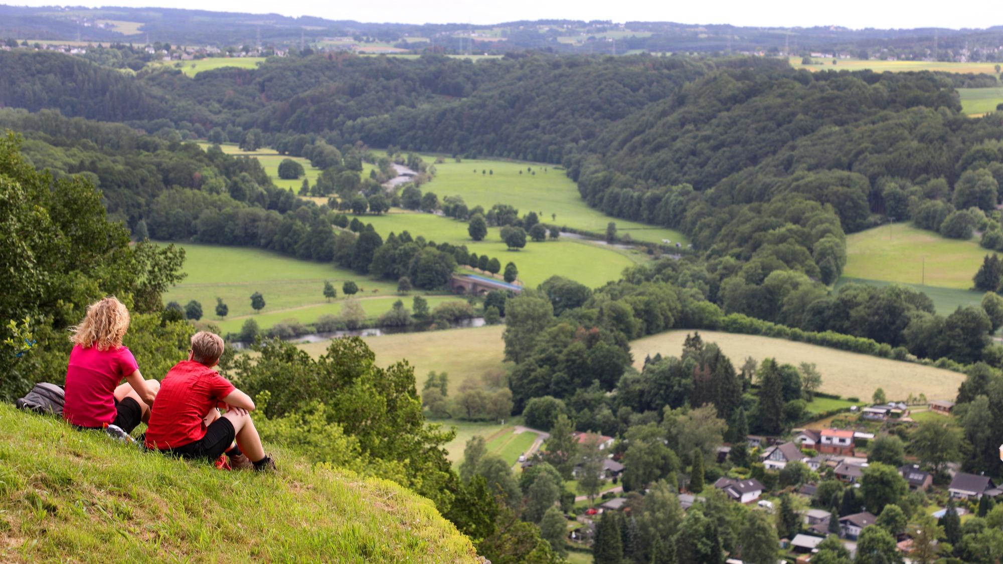 Zwei Frauen sitzen auf der Wiese auf der Stachelhardt und schauen ins Siegtal.