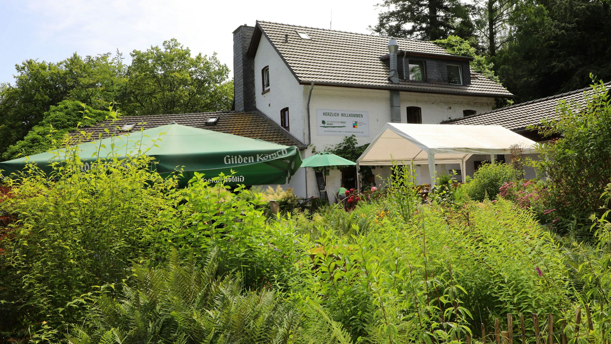 Hinter viel Grün ist das Naturfreundehaus Hardt in Bergisch Gladbach zu sehen.
