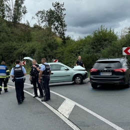 Das Foto zeigt eine Unfallstelle mit zwei beschädigten Autos, sowie Einsatzkräften von Polizei, Rettungsdienst und Feuerwehr.