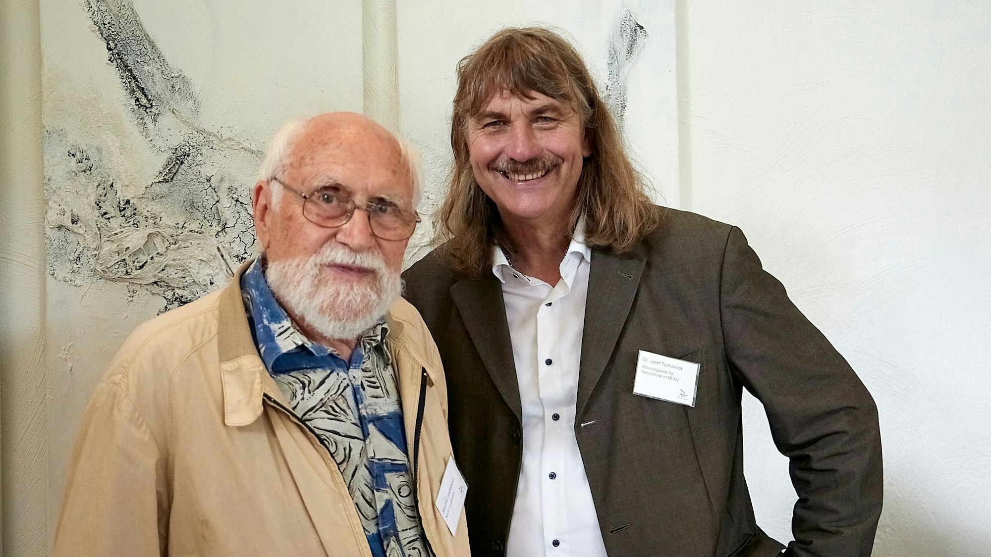 Manfred Weitkemper und Dr. Josef Tumbrinck stehen nebeneinander vor einem Kunstwerk.