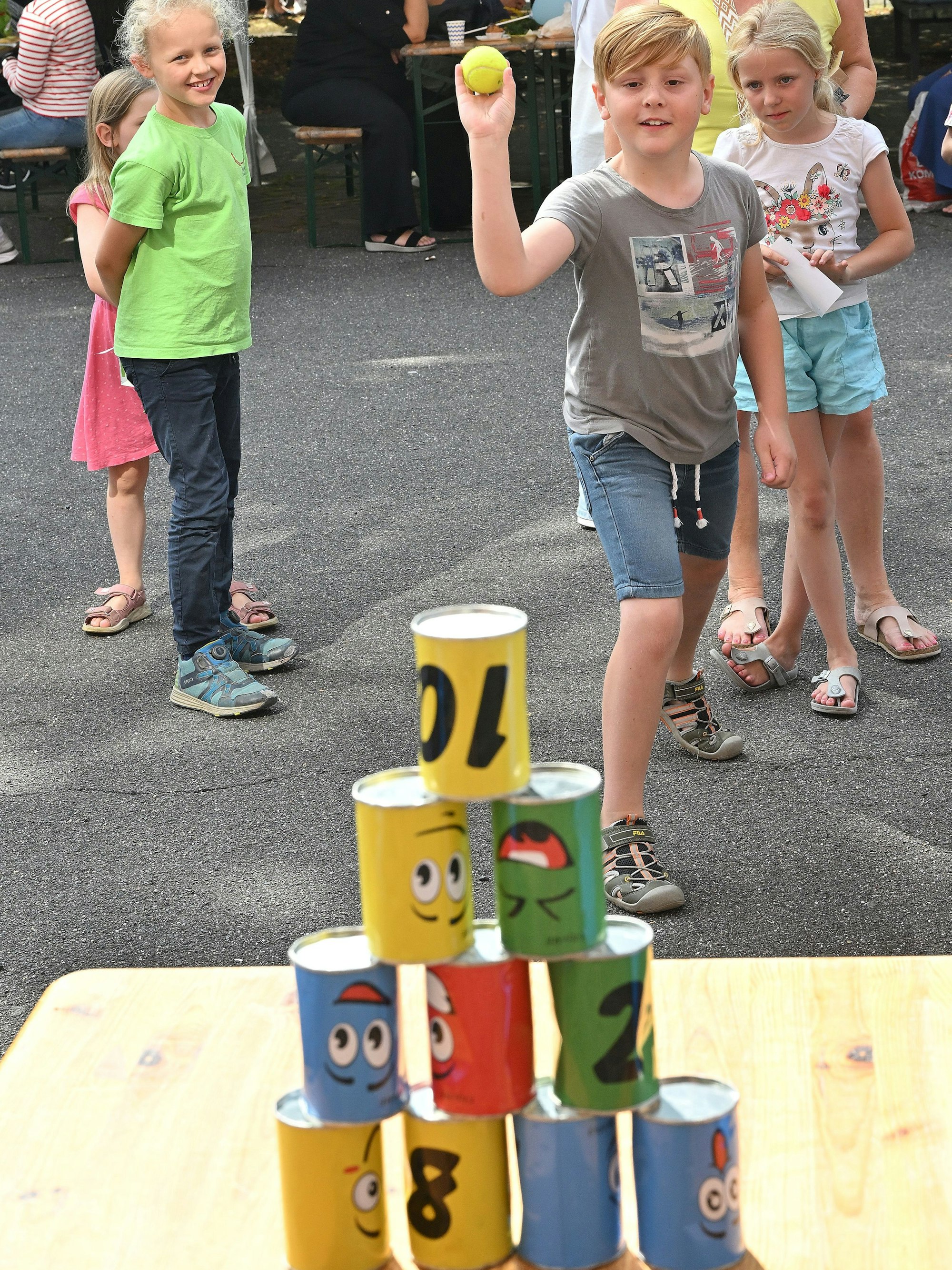 Ein Kind wirft auf Dosen beim Heidkamper Spielefest.