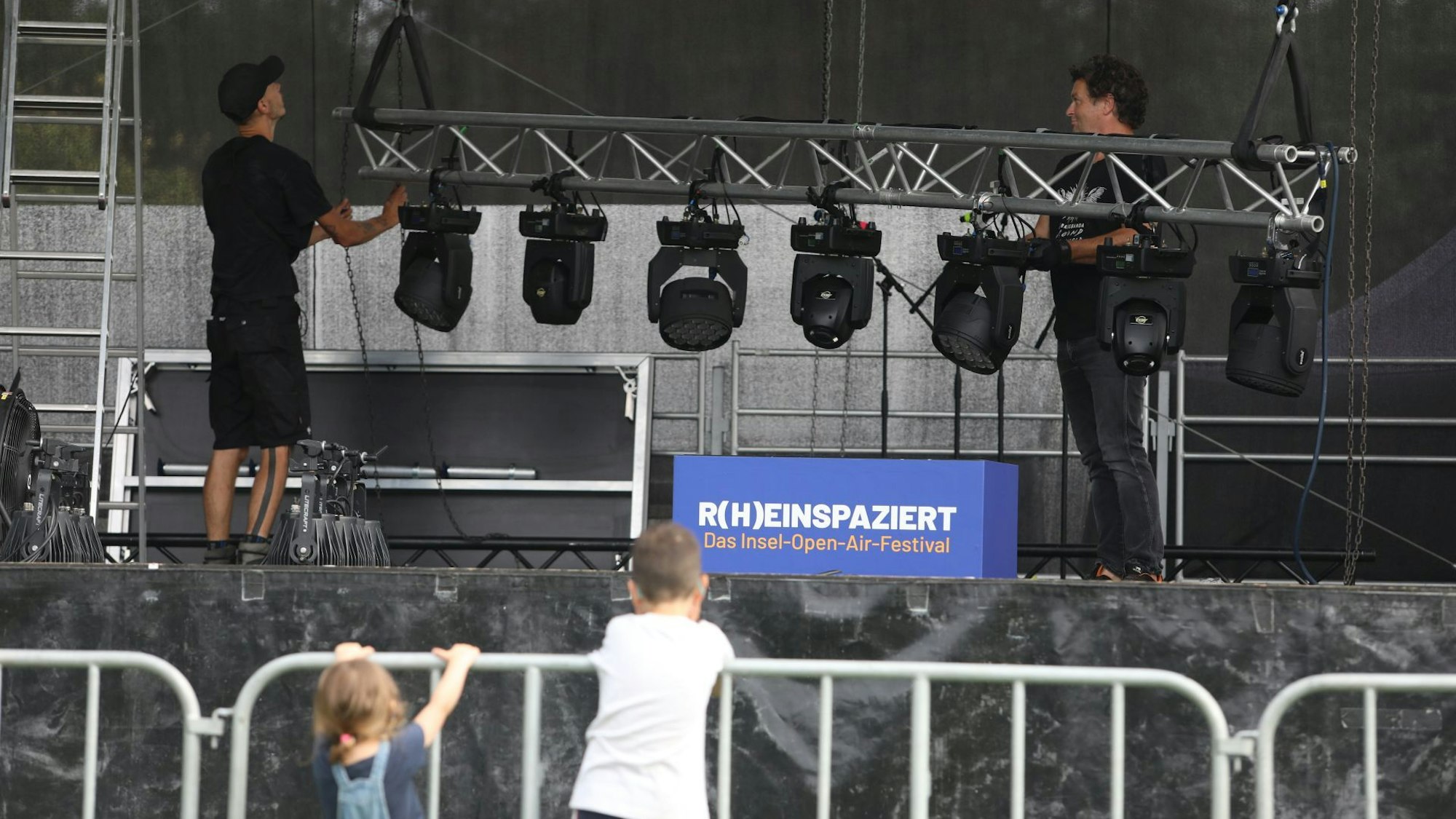 Eine leere Bühne, davor Kinder am Absperrgitter