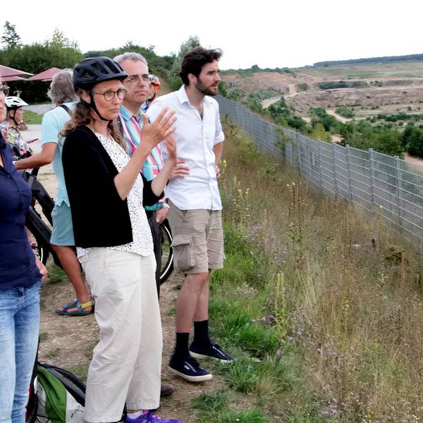 Frauen und Männer schauen auf die Weiten des Tagebaus Hambach.