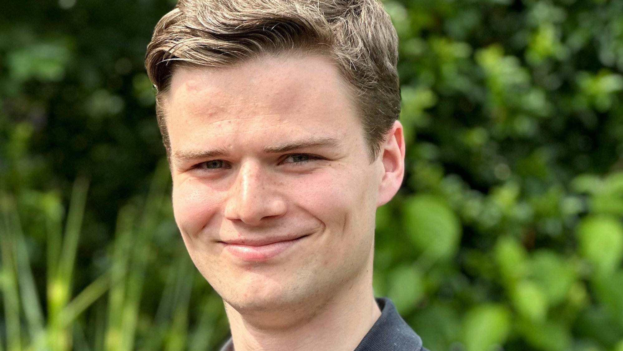 Max Rohde aus Bergisch Gladbach steht vor einem grünen Hintergrund.