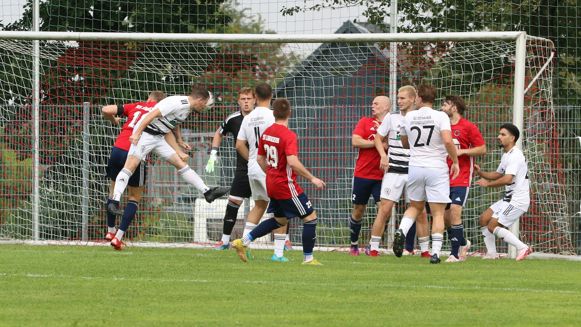 Ein Spieler des SC Erftstadt-Lechenich kommt vor dem Lommersumer Gegenspieler zum Kopfball und erzielt ein Tor.