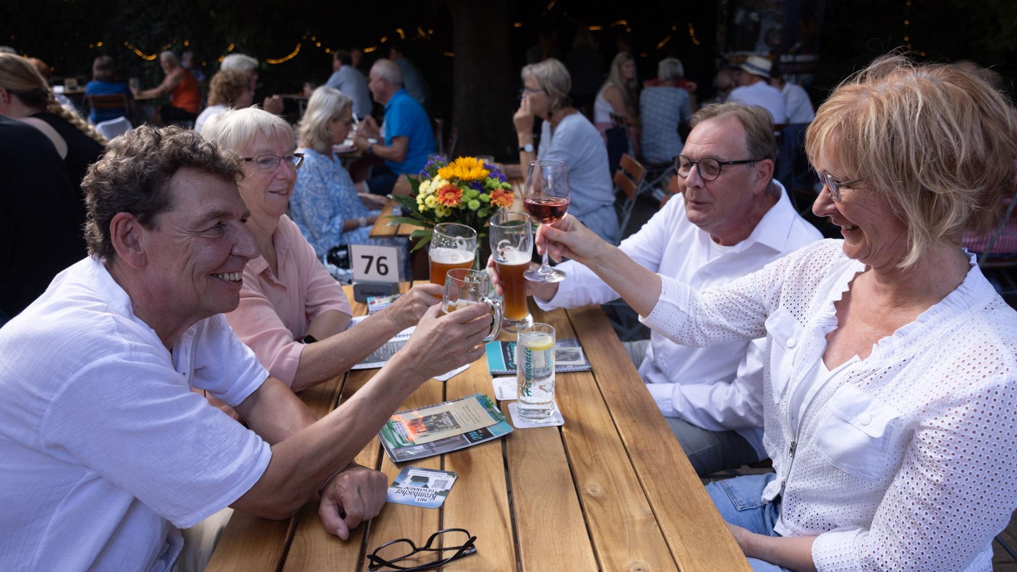 Eine Gruppe sitzt am Biertisch und protest sich zu.