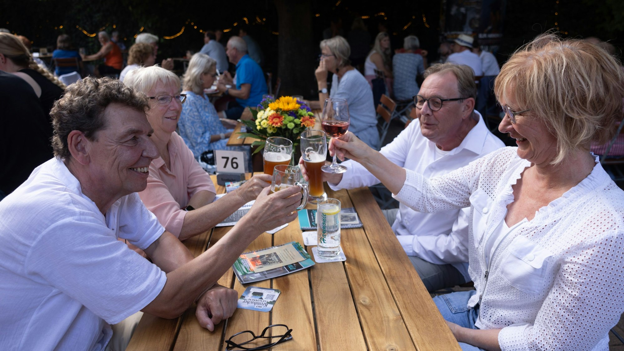 Eine Gruppe sitzt am Biertisch und protest sich zu.