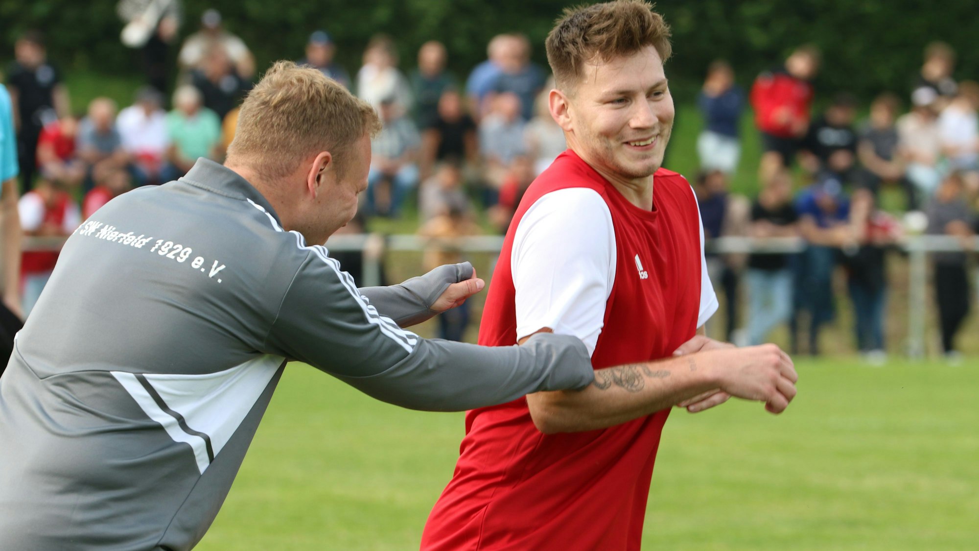 Nierfelds Sven Pohl scheint Ex-Mitspieler Maxi Patt zu fangen. Beide amüsieren sich köstlich.