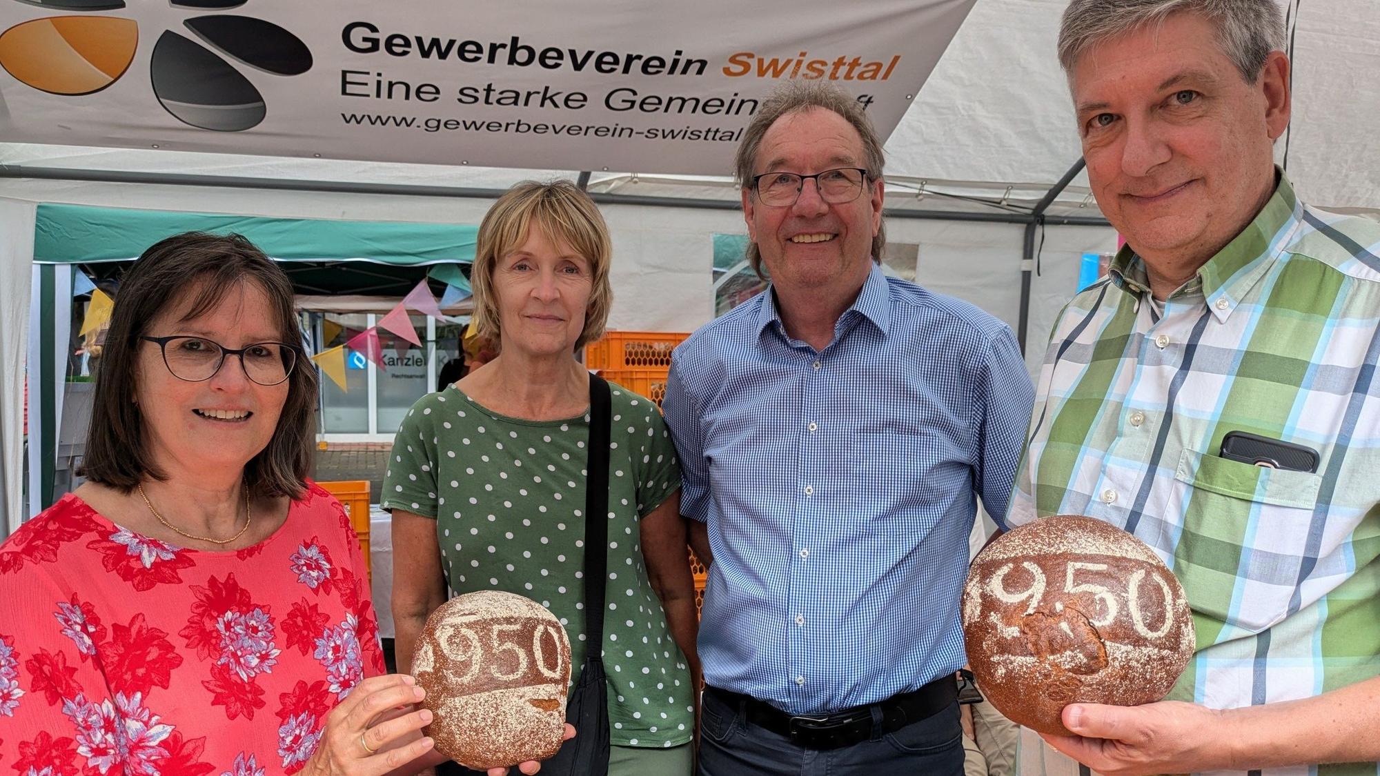 Vier Leute präsentieren das Jubiläumsbrot mit der Aufschrift 950.