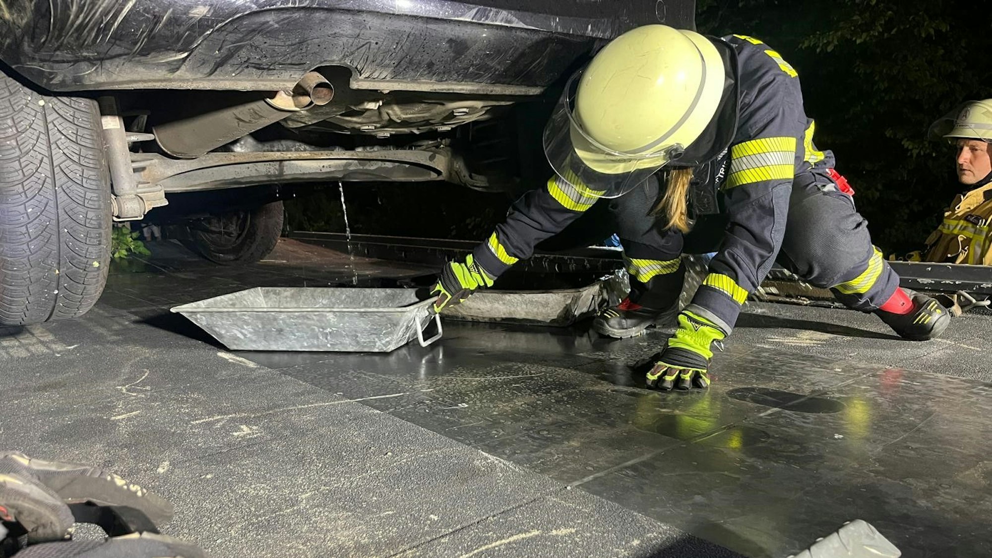 Ölwanne und Tank waren bei dem Unfall in Lohmar aufgerissen. Feuerwehrleute fingen den Treibstoff mit Wannen auf.