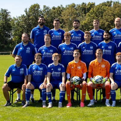 Die Mannschaft des SSV Weilerswist sitzt und steht aufgereiht auf einem Rasenplatz. Im Hintergrund stehen Bäume.