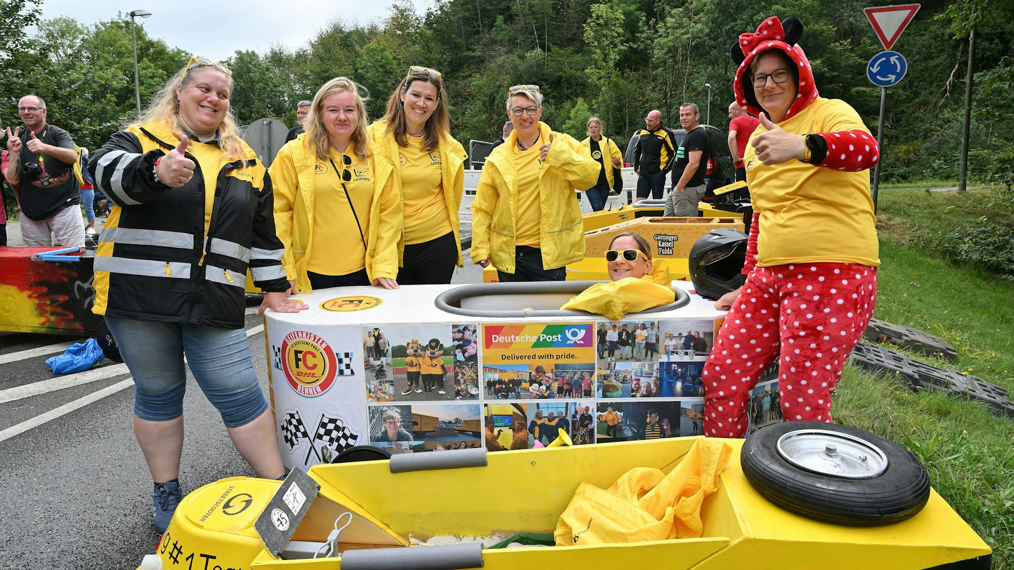 Frauen stehen um eine Seifenkiste mit einer weiteren Frau am Steuer.