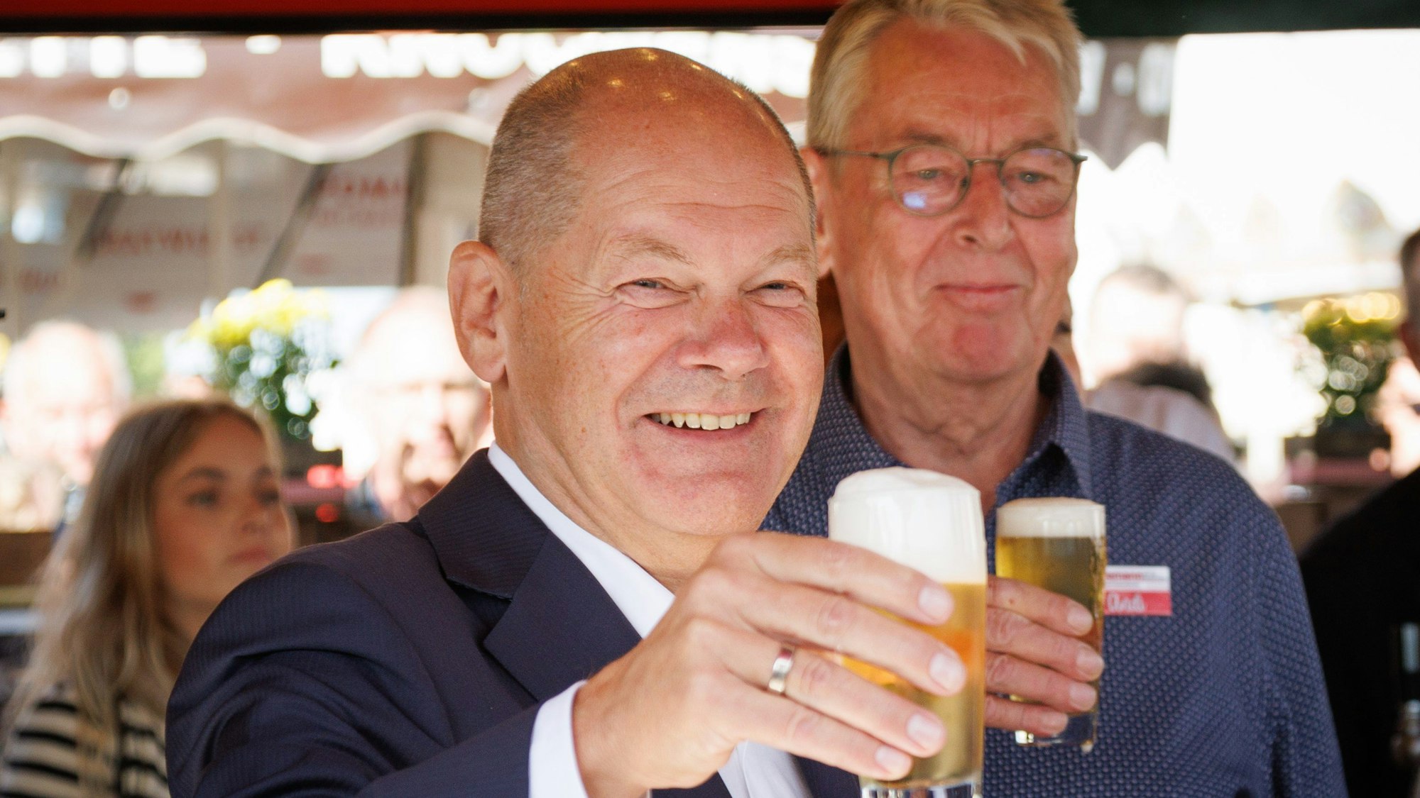 Bundeskanzler Olaf Scholz (SPD) hält ein selbstgezapftes Glas Bier beim 726. Stoppelmarkt in Vechta.