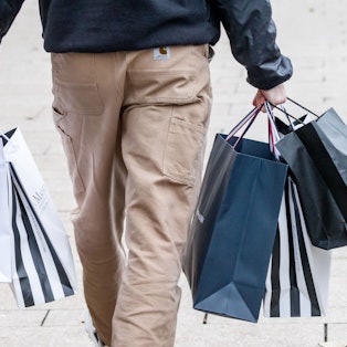 Ein Mann geht mit Einkaufstüten durch die Innenstadt. (Symbolbild)