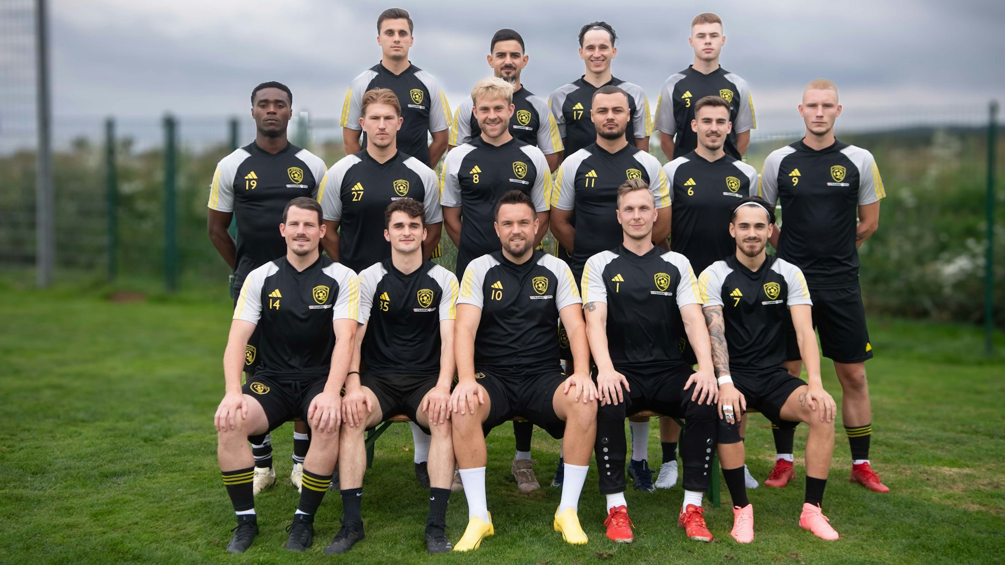 Der SC Germania Erftstadt-Lechenich hat sich für ein Mannschaftsfoto auf einem Rasen versammelt. Im Hintergrund ist der Himmel bewölkt.