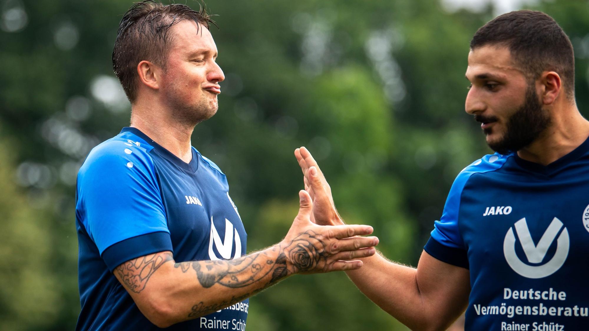 Das Bild zeigt Michal Jedrowski, der sich mit einem Mitspieler über seinen Treffer mit einem Handschlag freut.