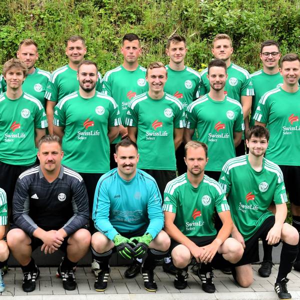 Das Mannschaftsfoto zeigt die Mitglieder des SV Schöneseiffen auf hartem, gekachelten Untergrund vor einer Grünfläche.