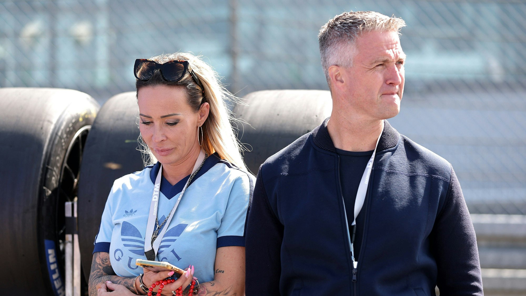 Cora Schumacher und Ralf Schumacher stehen nebeneinander und blicken kritisch in entgegengesetzte Richtungen.