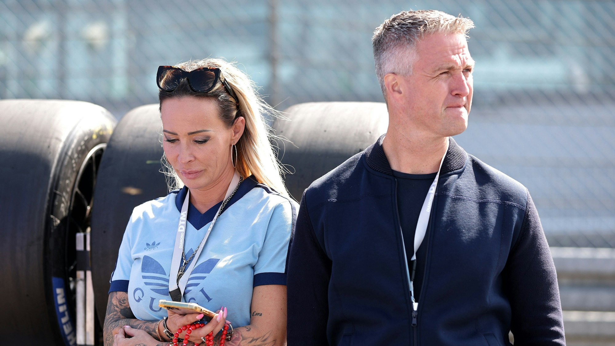 Cora Schumacher und Ralf Schumacher stehen in einer Boxengasse.