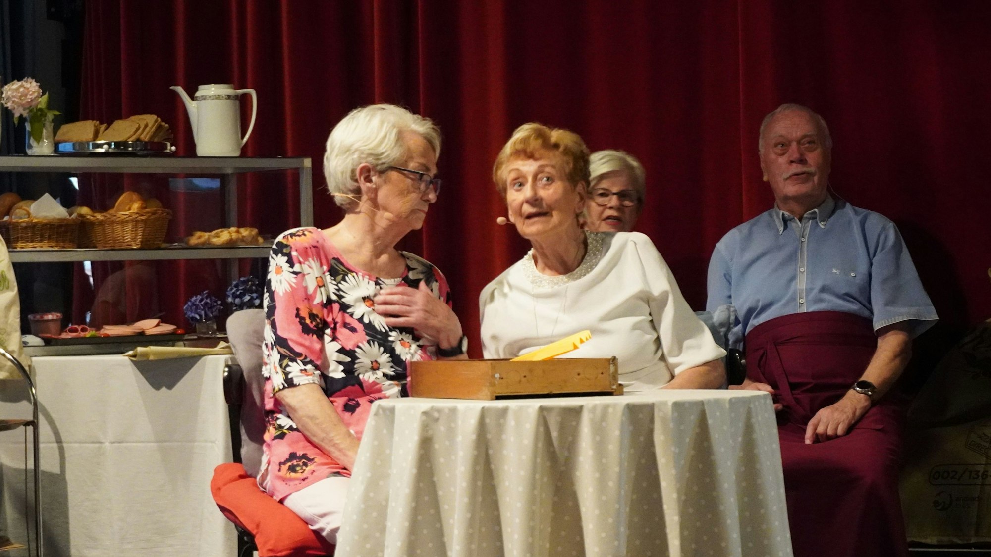 Zwei Frauen sind an einem Tisch in einem Café, sie sind in ein Gespräch vertieft.