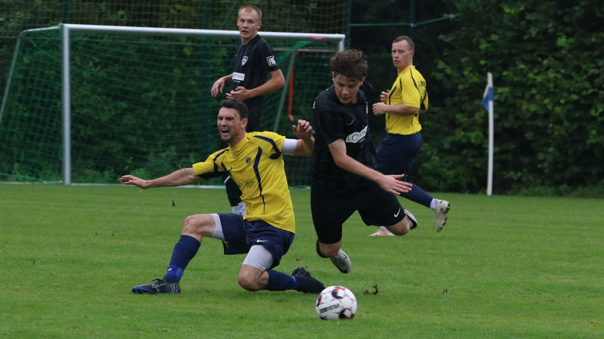 Das Bild zeigt das Duell zwischen Schneider und Riße. Letztgenannter landet unsanft auf dem Rasen.