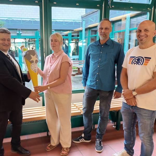 Drei Männer, eine Frau und eine kleine Schultüte