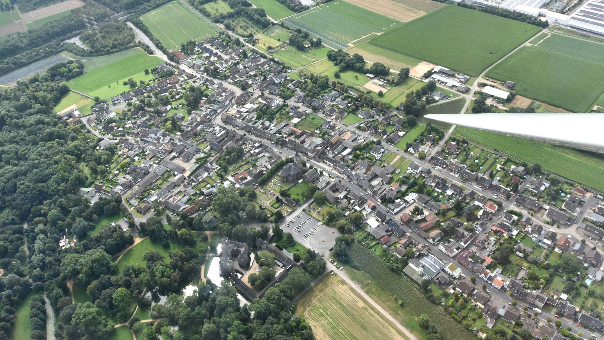 Zu sehen ist eine Stadt und Landschaft von oben aus einem Flugzeug.