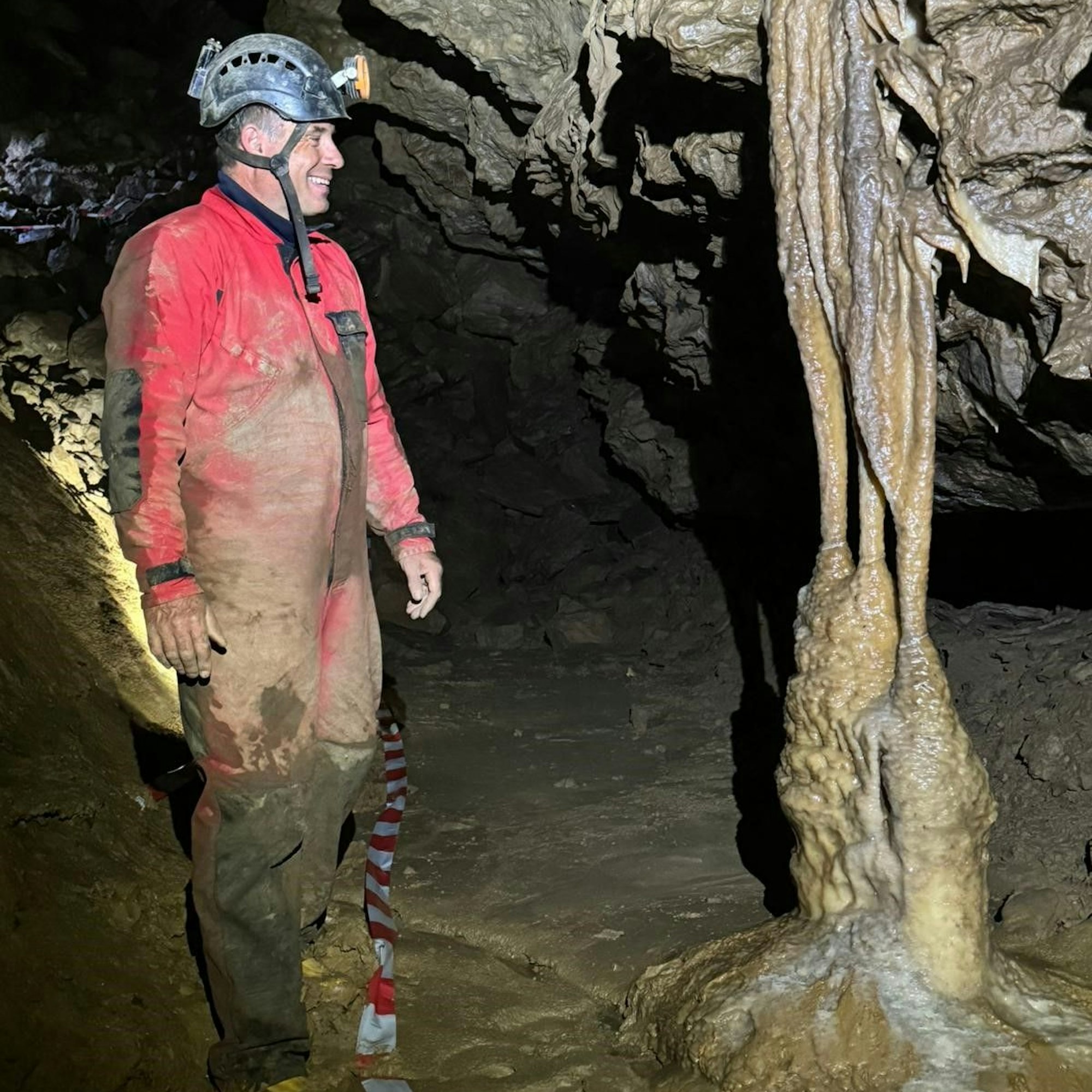 Stefan Voigt steht im Hackerloch neben einer imposanten, zweieinhalb Meter hohen Tropfsteinsäule, die den Namen Poseidonsäule erhalten hat.