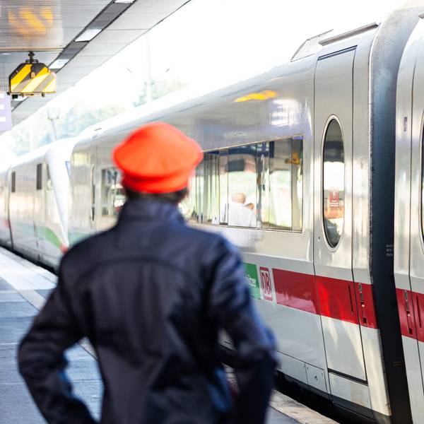Ein Mitarbeiter der Deutschen Bahn (DB) steht neben einem ICE-Zug an einem Gleis im Hauptbahnhof Hannover.