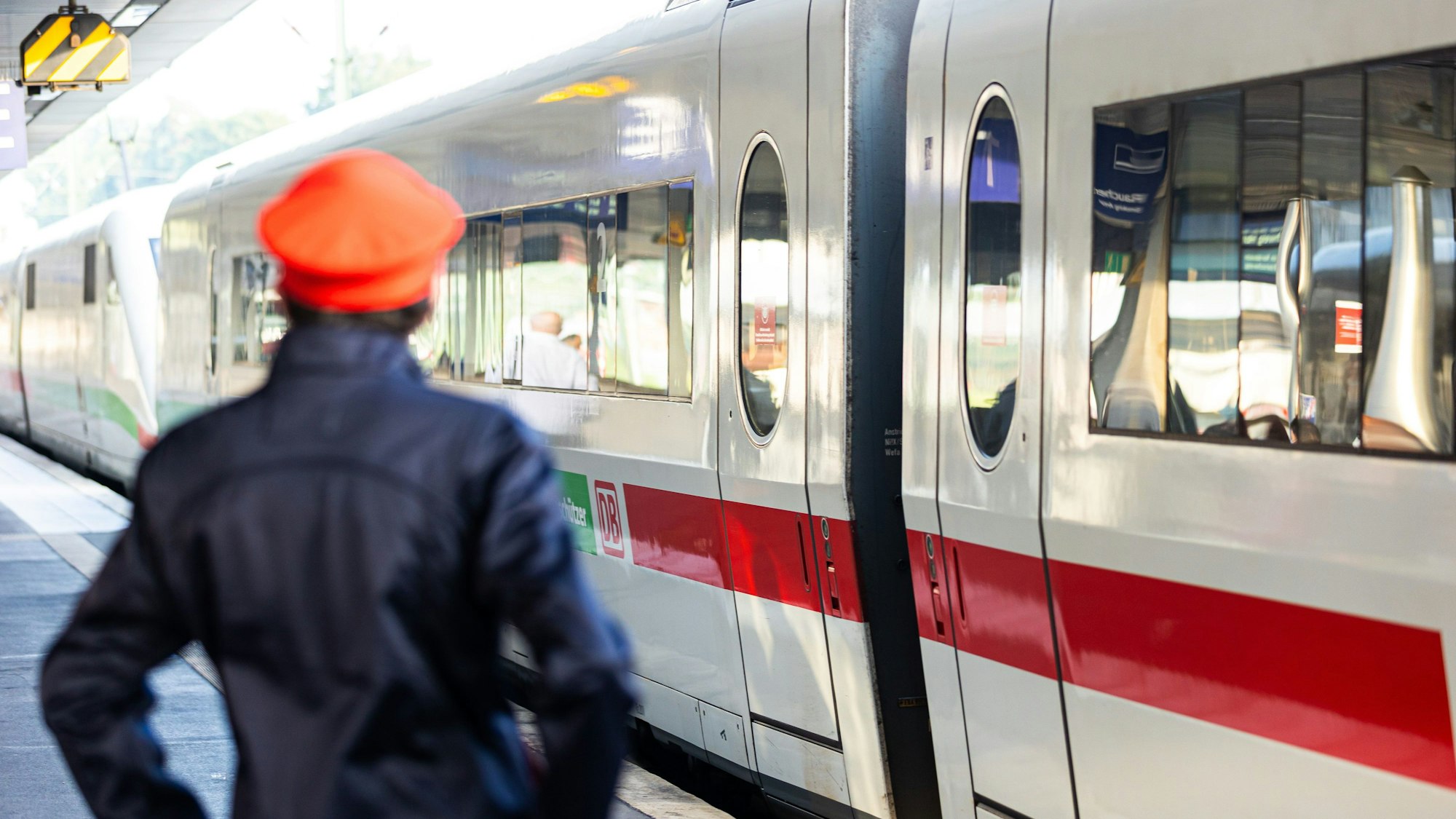 Ein Mitarbeiter der Deutschen Bahn (DB) steht neben einem ICE-Zug an einem Gleis im Hauptbahnhof Hannover.