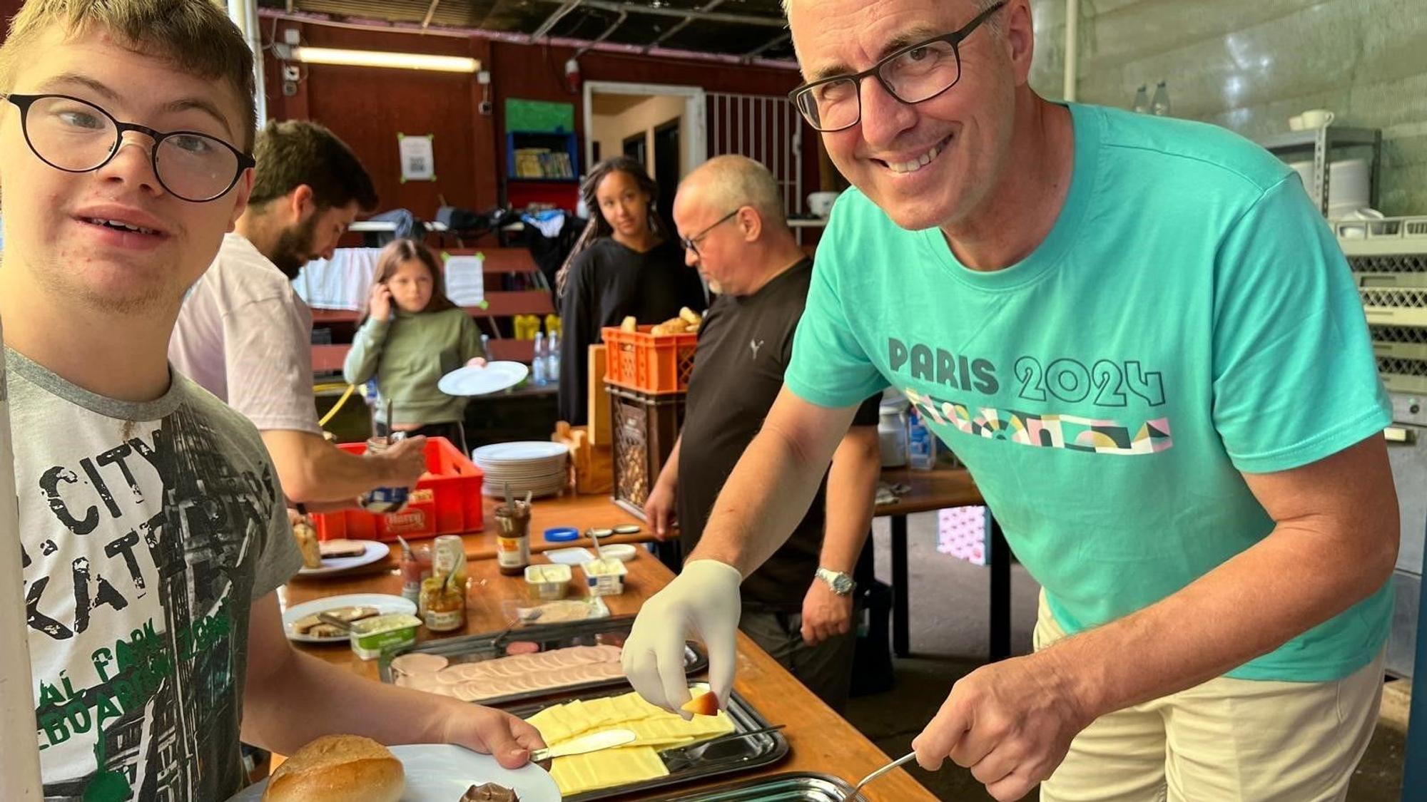 Ein Camp-Teilnehmer bei der Frühstücksausgabe mit Bürgermeister Andreas Wolter.