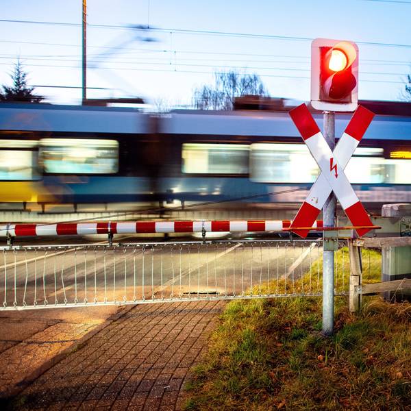 Ein Nahverkehrszug passiert einen Bahnübergang.