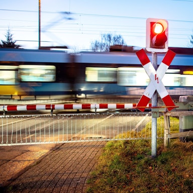 Ein Nahverkehrszug passiert einen Bahnübergang.