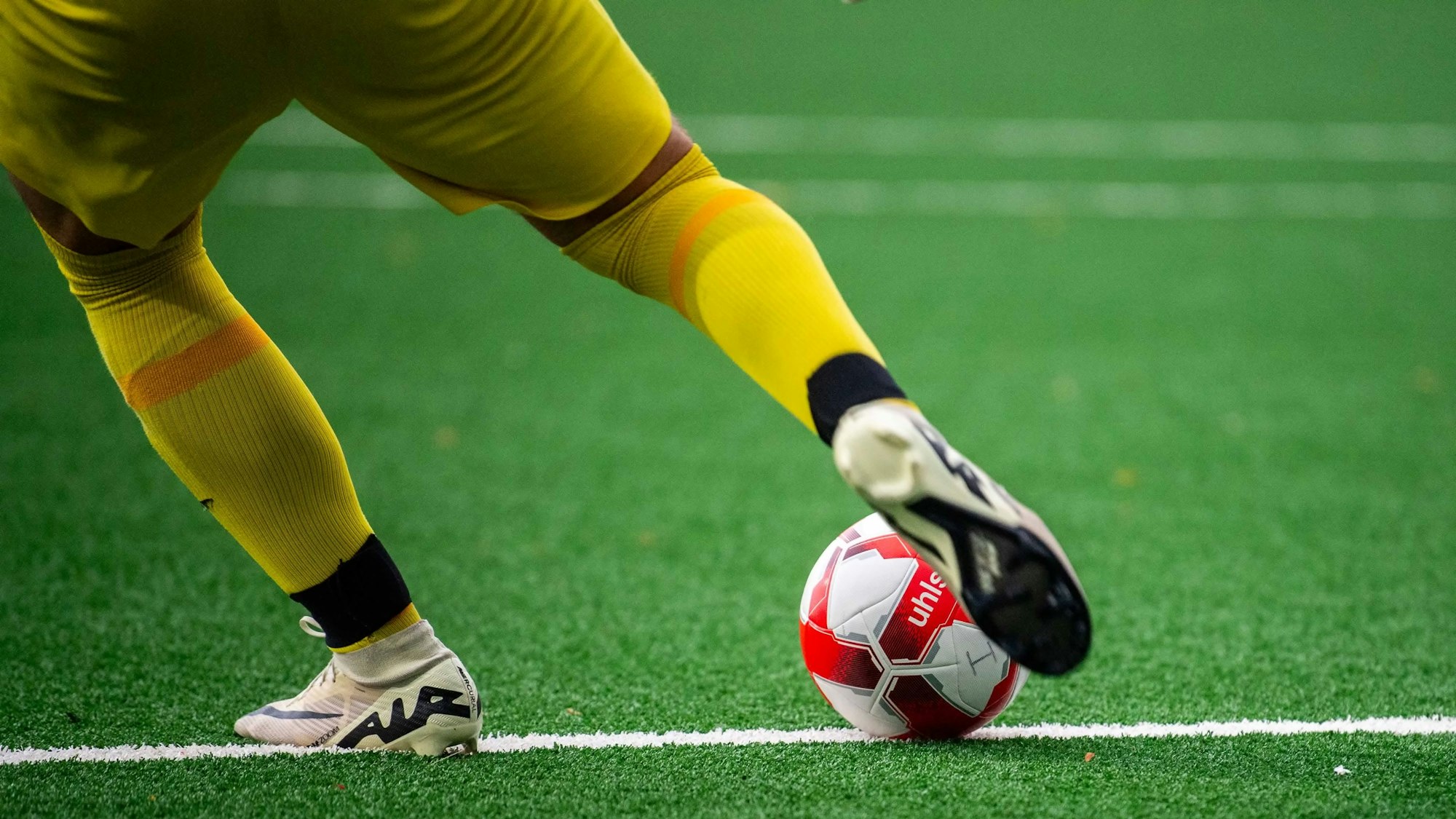 Ein Fußballtorwart schießt einen Ball vom Boden aus.