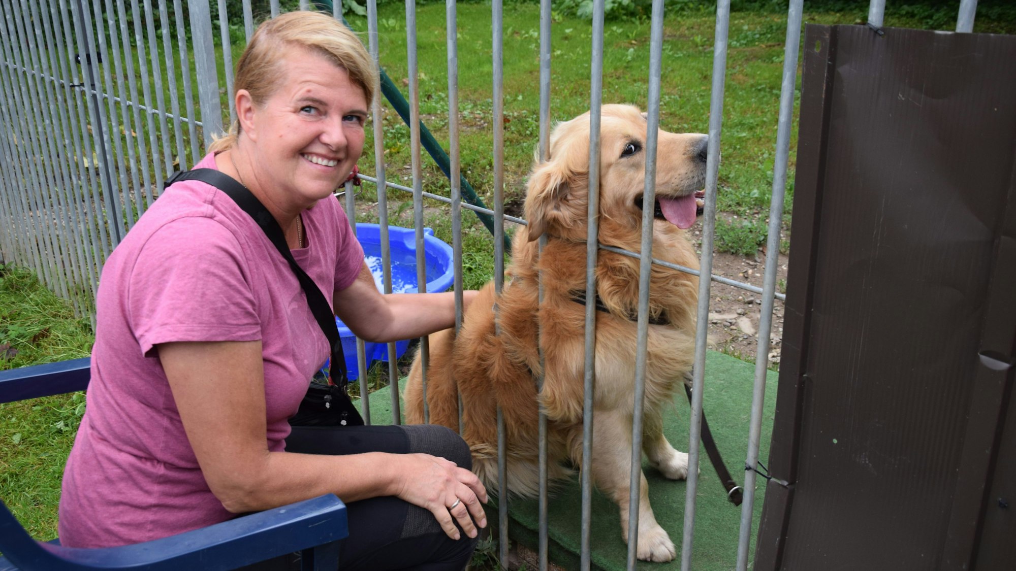 Silvia Schulisch streichelt den Golden Retriever Mischling Marley.