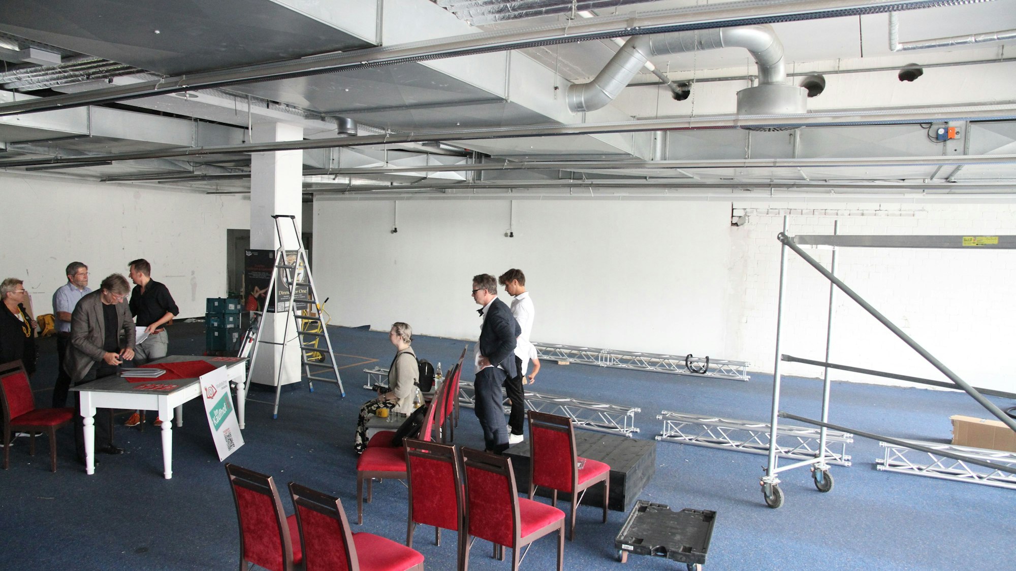 Fünf Männer und zwei Frauen in einer leerstehenden Warenhausetage