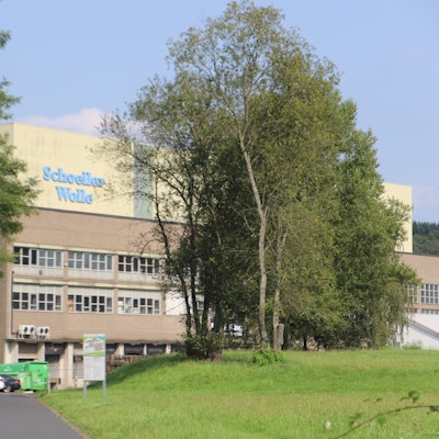 Das große Lagergebäude trägt den Schriftzug Schoeller Wolle.